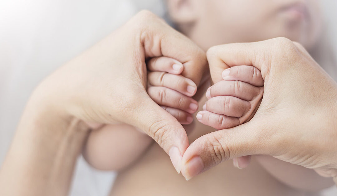 Mani di mamma che tengono le mani del suo bimbo