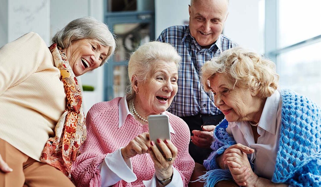 Anziani che guardano un cellulare e ridono